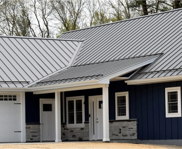 Newly constructed modern house with dark blue siding and a metal roof.